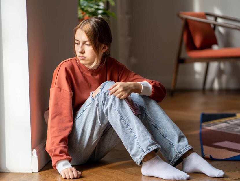 Ragazza triste seduta a terra