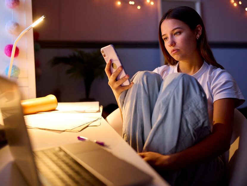 Adolescente al cellulare nella sua stanza