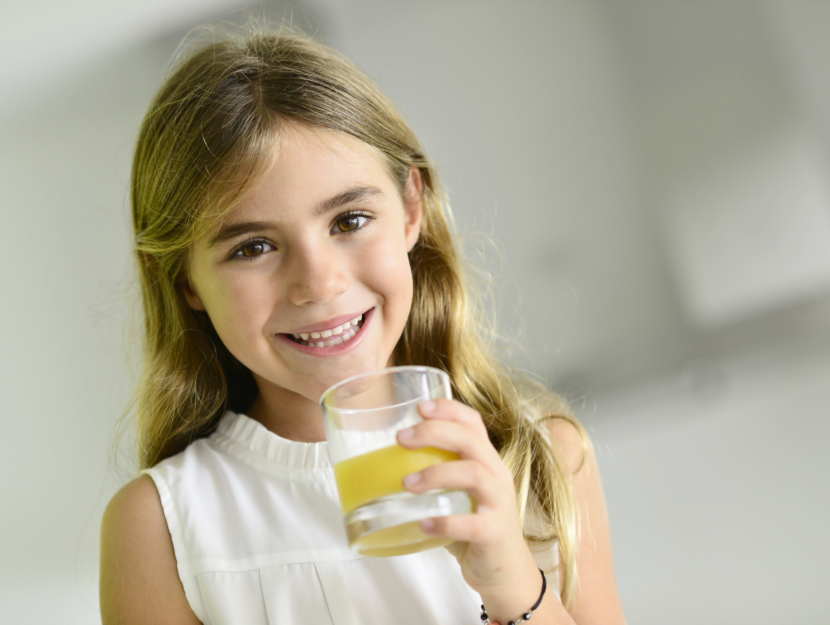 Bambina beve un succo di frutta