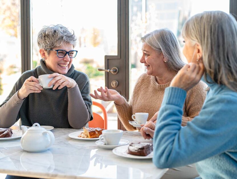 Tre amiche ridono durante la colazione