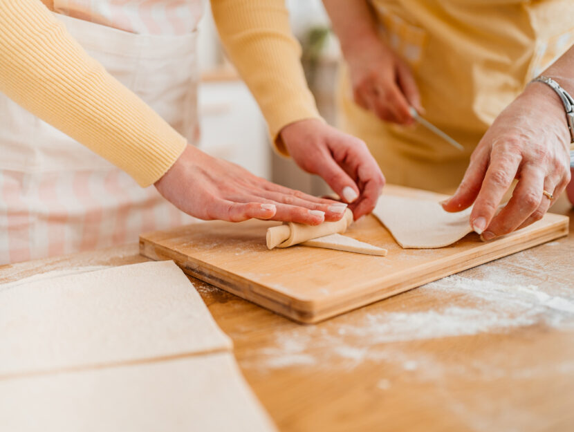 signore stanno arrotolando la pasta sfoglia a formare cornetti