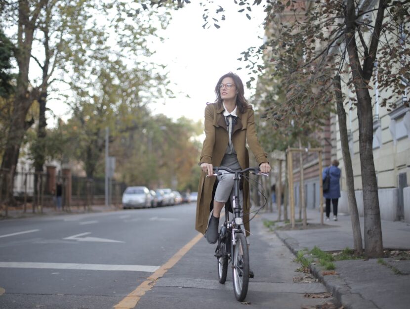 ragazza sulla bici mentre va a lavoro vestita elegante
