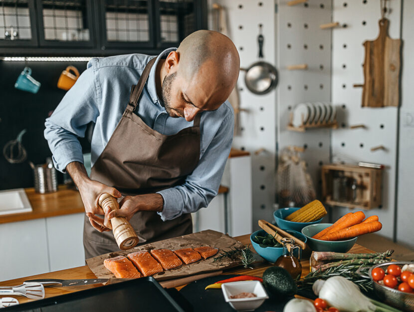 un ragazzo sta cucinando il salmone