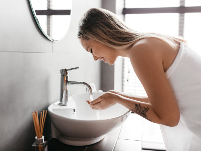 ragazza si sta lavando il viso nel lavandino