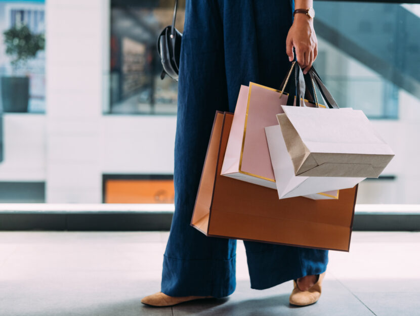 ragazza sta facendo shopping con molti sacchetti in mano