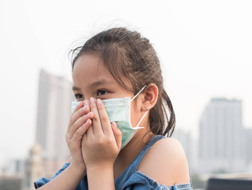 Una bambina con la mascherina per proteggersi dallo smog