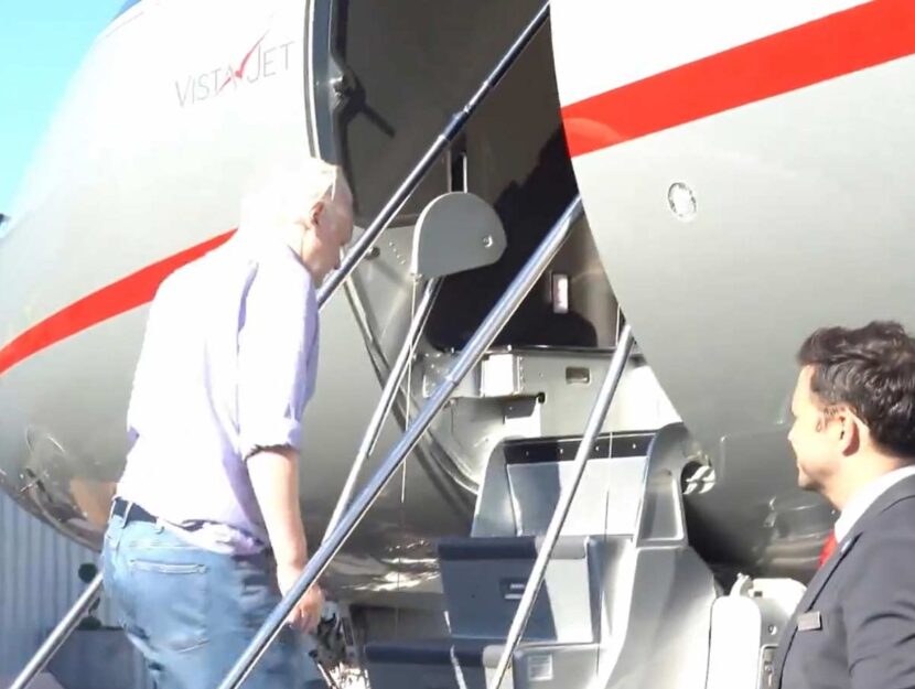 Julian Assange si imbarca su un aereo dopo la liberazione