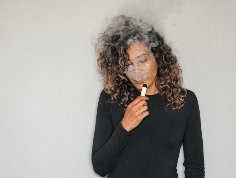 ragazza sta fumando la sigaretta elettronica