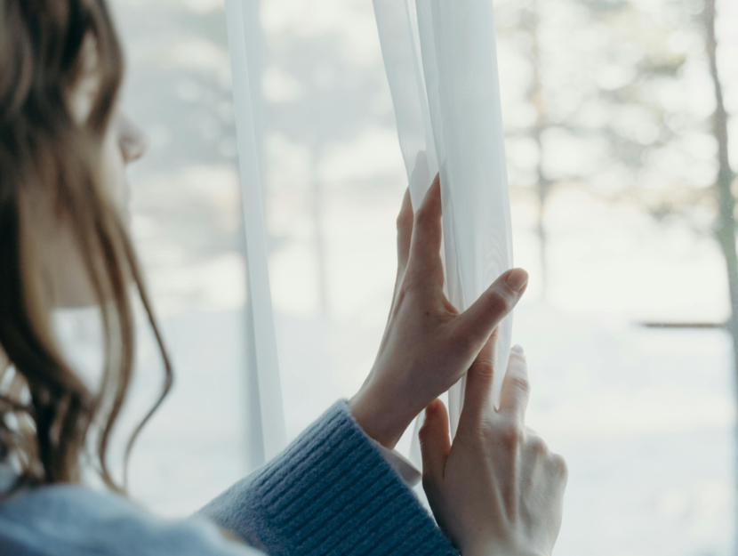 Genitore guarda fuori dalla finestra pensando ai figli