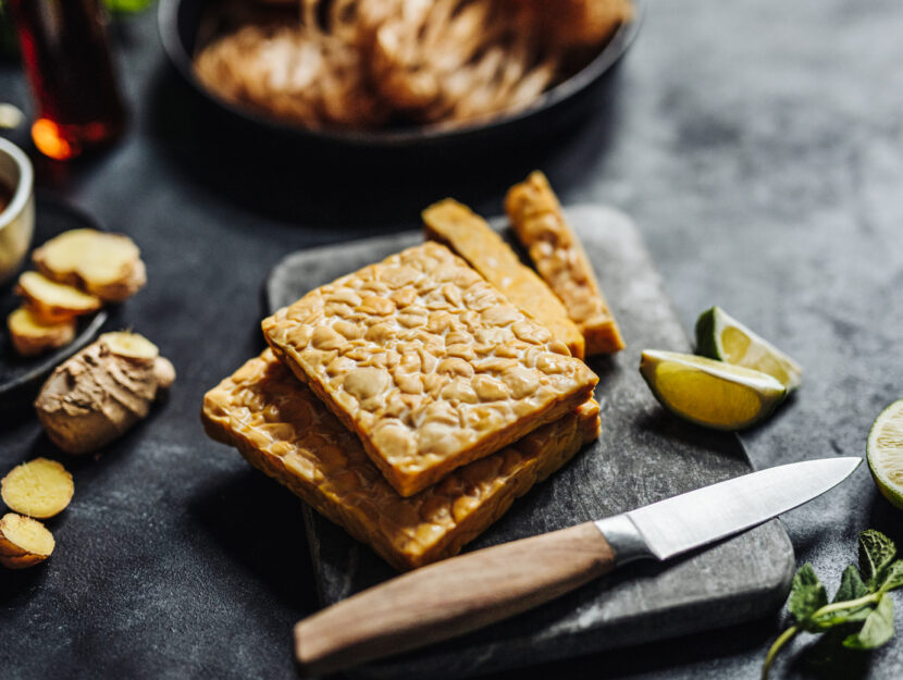 piatto di tempeh sul tavolo con altri ingredienti