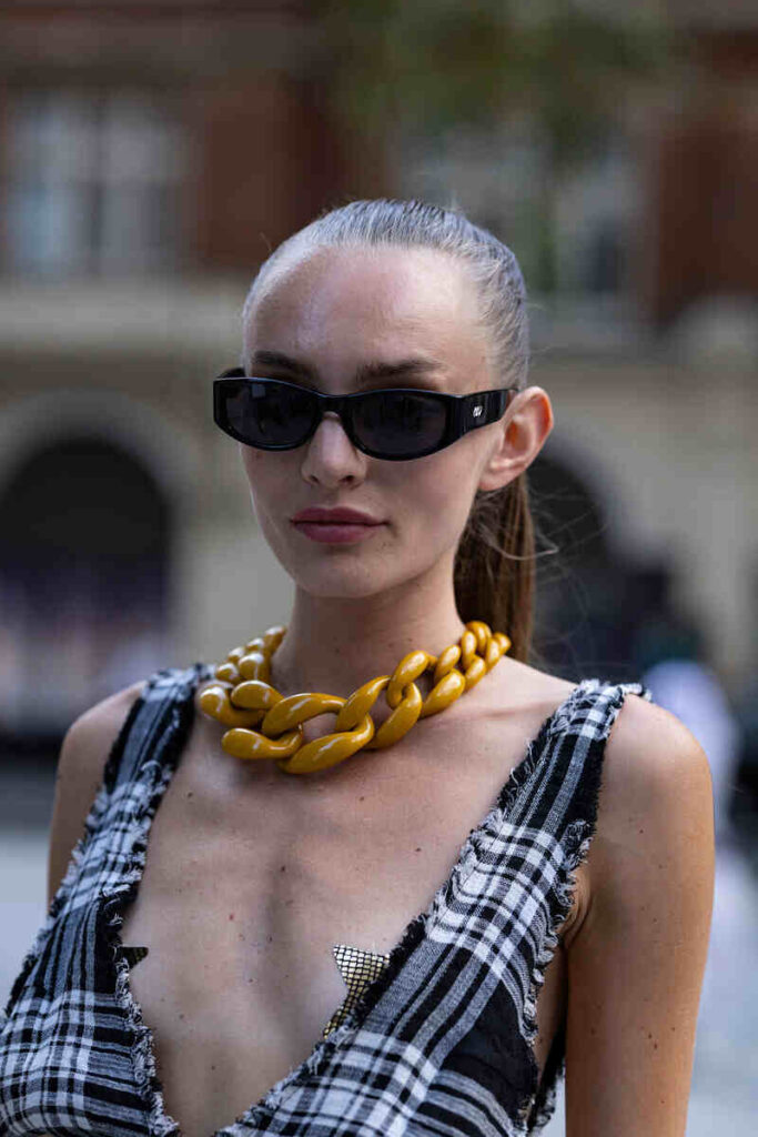 giovane donna mezzo busto con occhiali scuri e capelli tirati in coda di cavallo