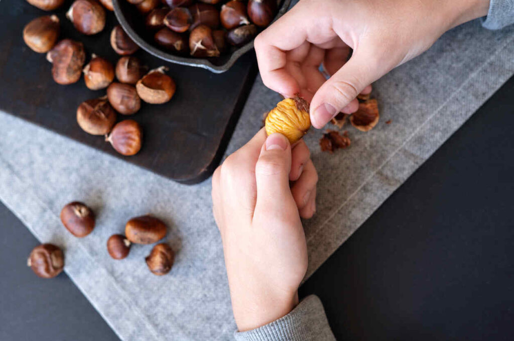 mani che sbucciano castagne