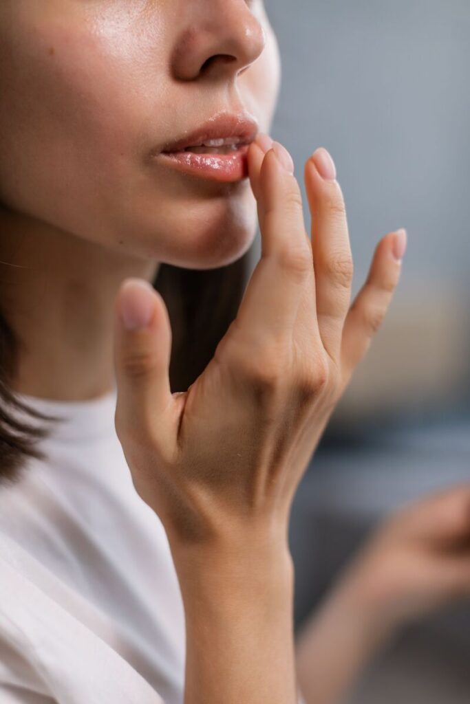 viso di donna che si applica balsamo su labbra