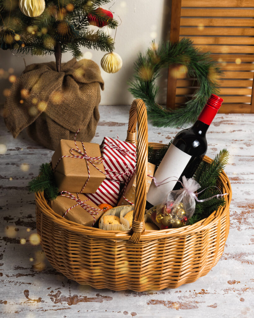 cesto di regalo natalizio con bottiglia di vino e gourmandise