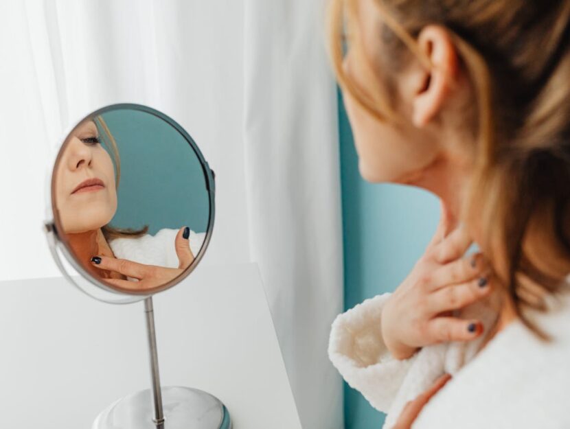 donna che si spalma la crema sul collo