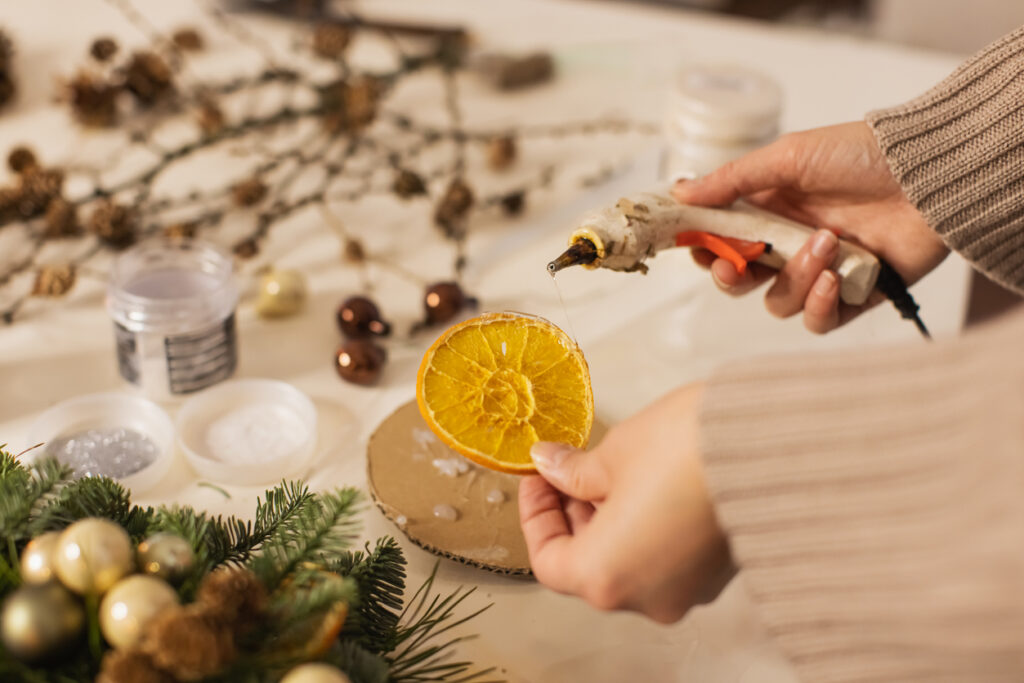 Una donna sta creando decorazioni di natale con arance essiccate