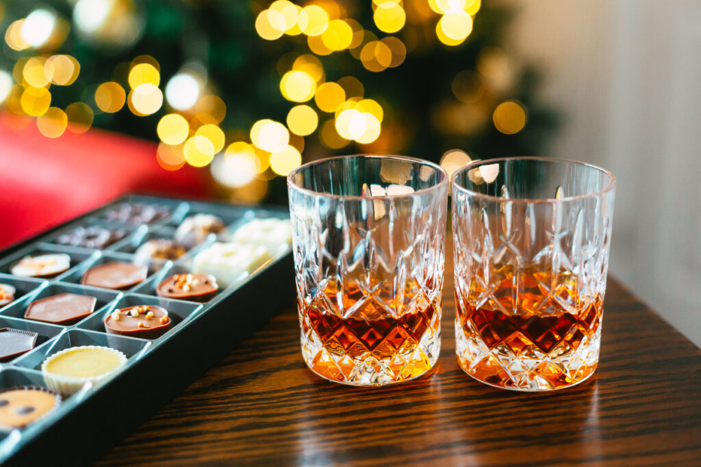 bicchieri con amaro accanto a una scatola di cioccolatini