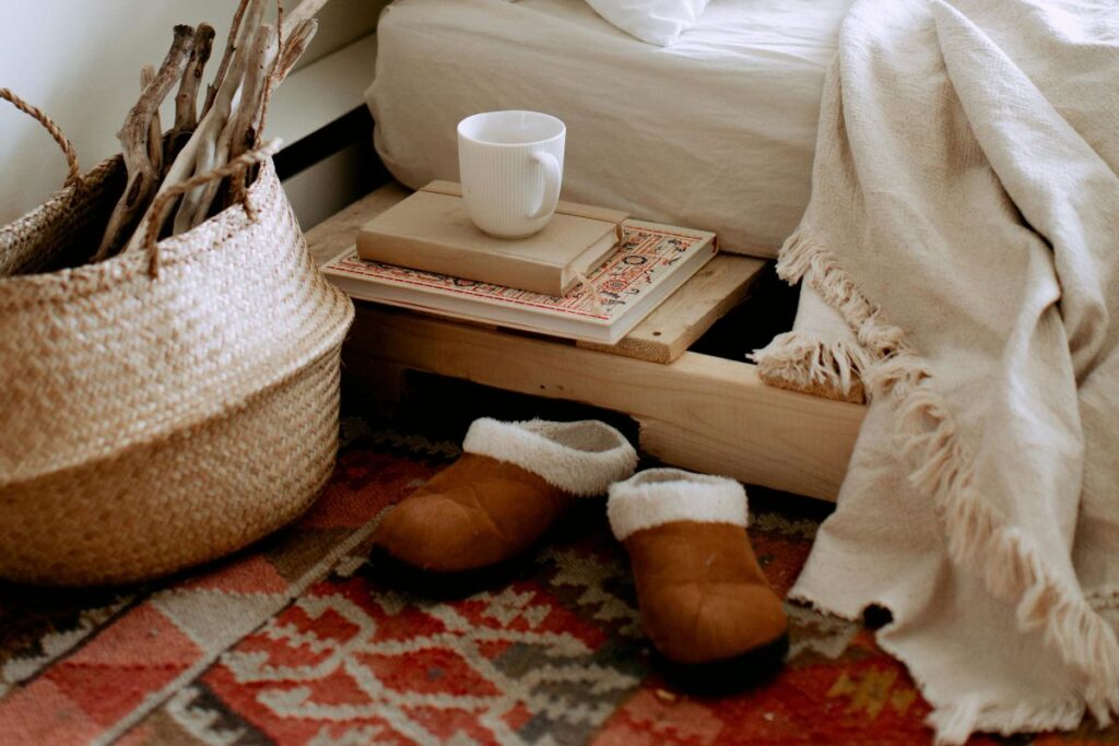 letto con tappeto con pantofole poggiate sopra