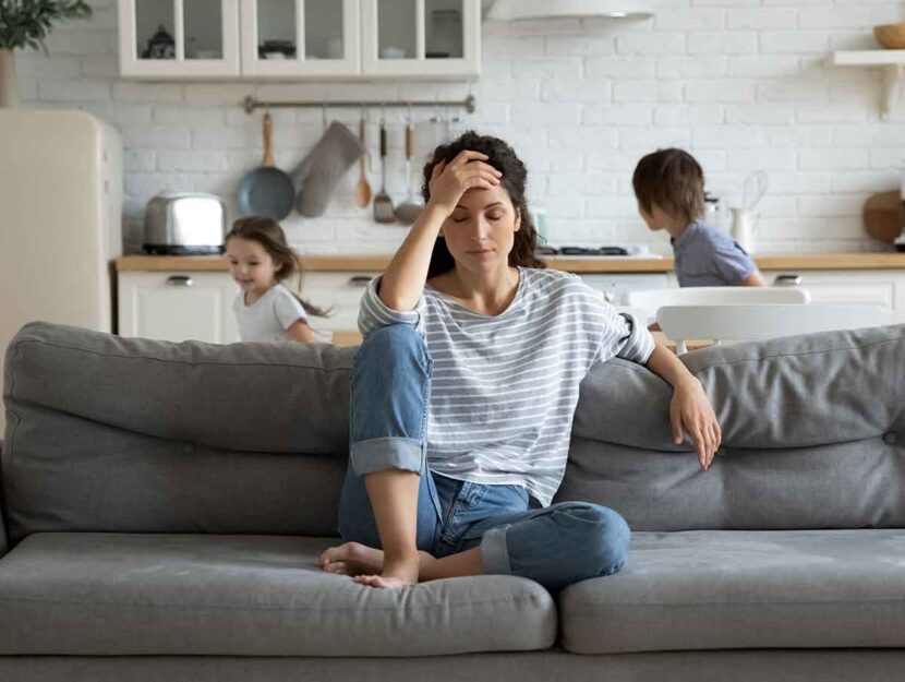 Mamma sul divano mentre i bambini giocano