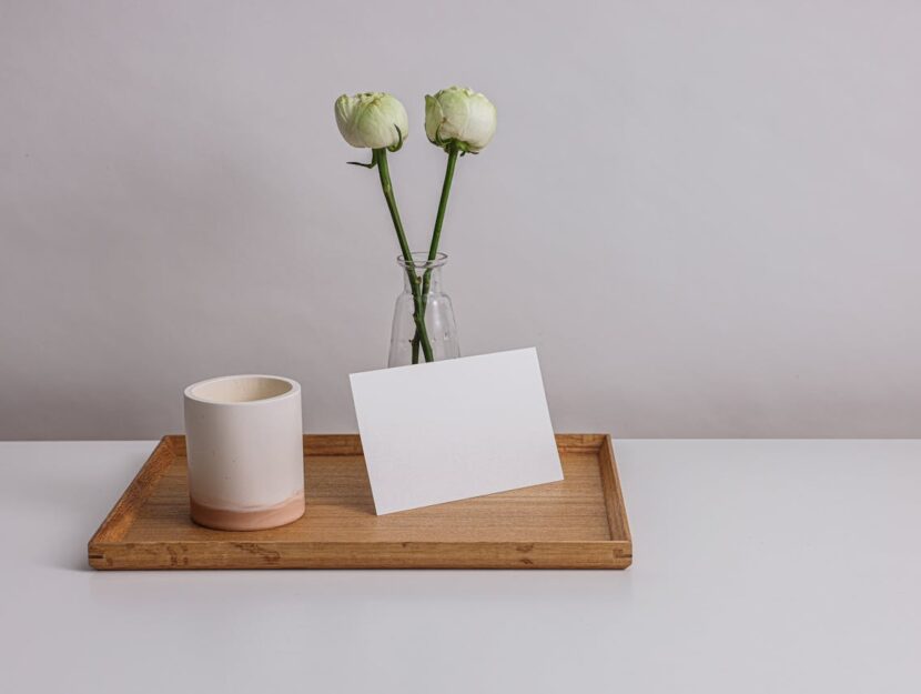 busta da lettera su vassoio con fiori e bicchiere