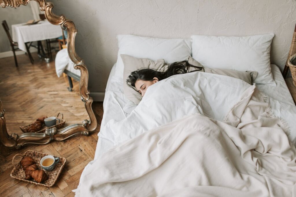 ragazza dorme nel letto sotto il piumone
