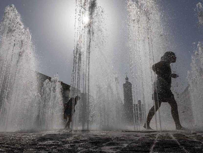 Bambini si bagnano a una fontana per il caldo