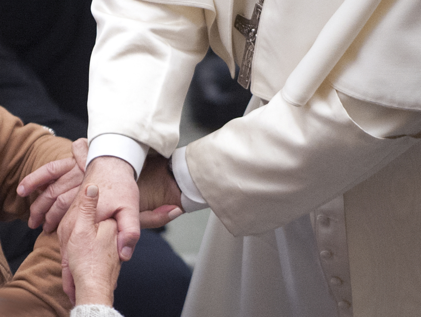 Papa Francesco stringe le mani a due fedeli