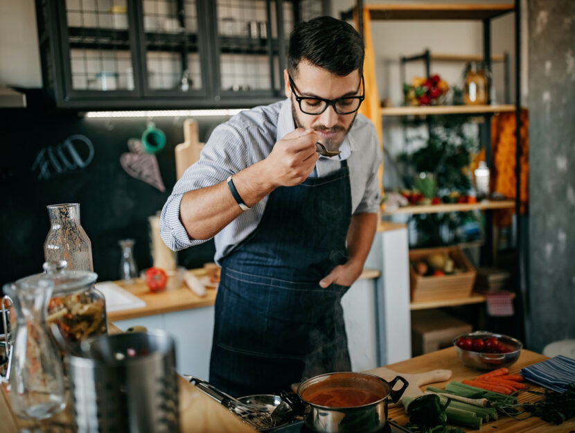 ragazzo mescola quello che ha cucinato in pentola