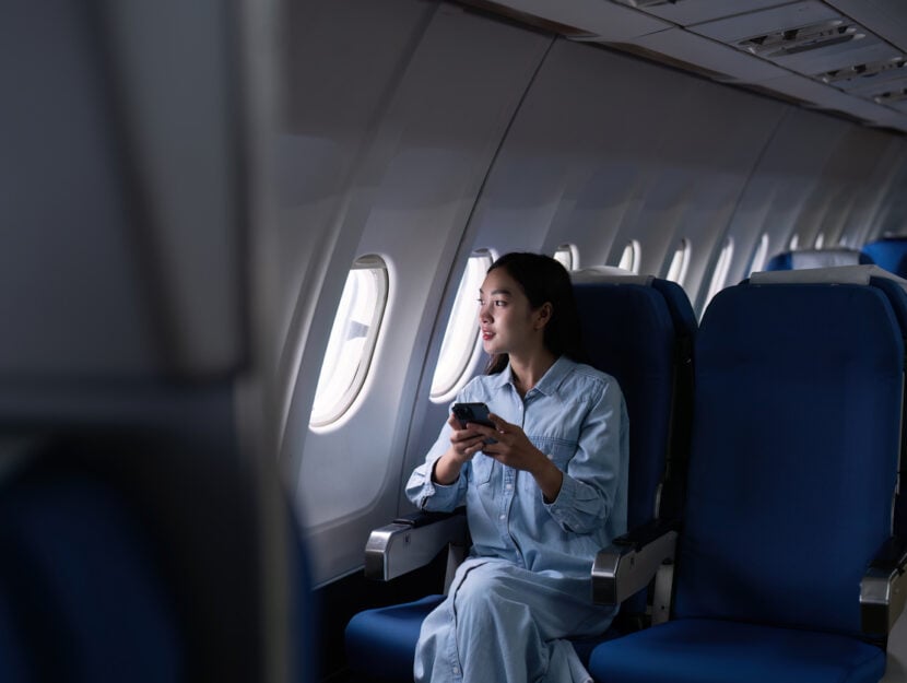 ragazza che usa il telefono in aereo