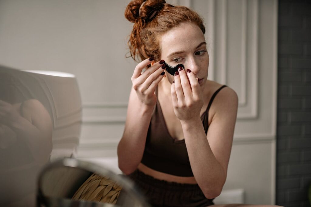 ragazza si applica i patch sugli occhi