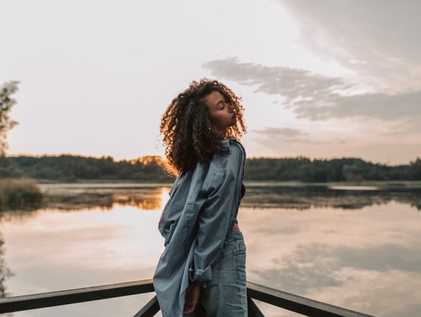 ragazza con capelli ricci davanti a un paesaggio