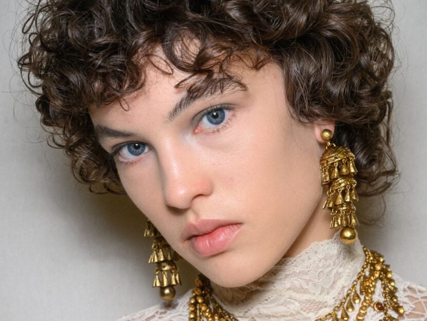 ragazza con capelli ricci corti con frangia