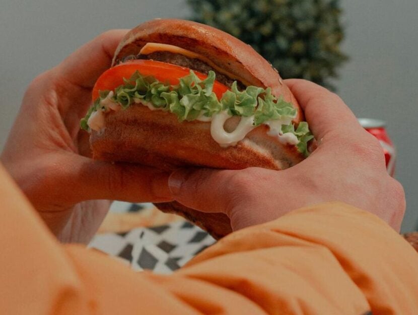 persona che mangia un hamburger