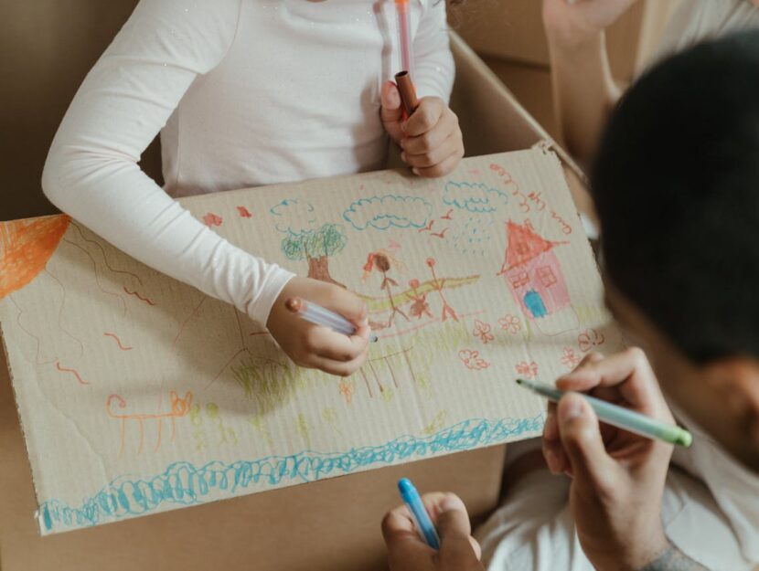 papà e figlia disegnano sulla scatola di cartone