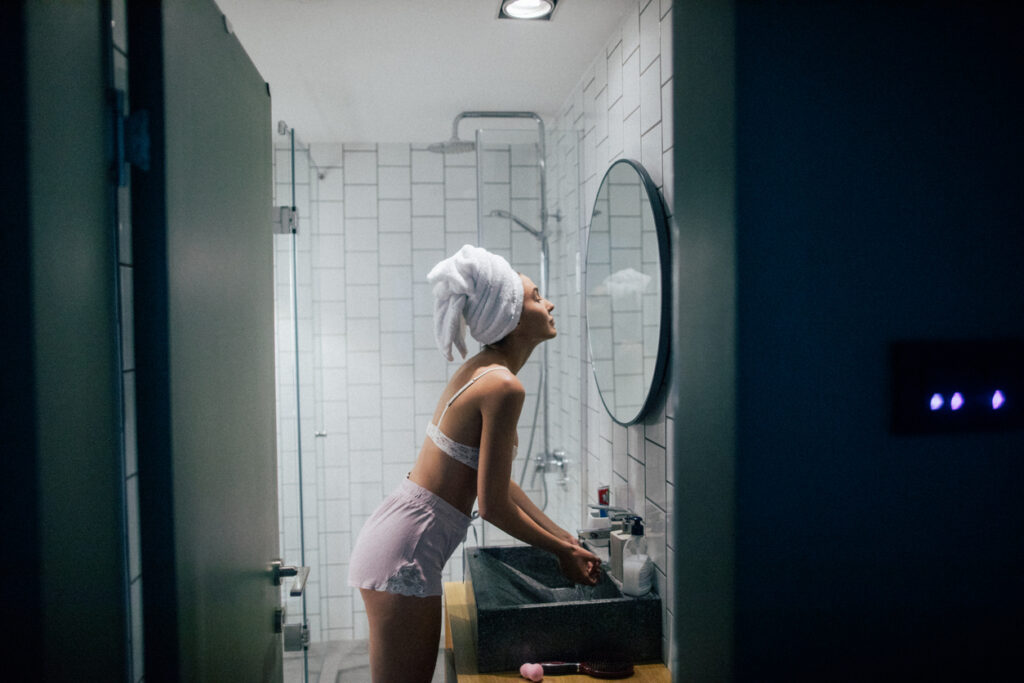 ragazza si guarda allo specchio dopo aver fatto una doccia