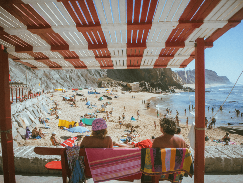 Bagnanti in spiaggia sotto al sole alla ricerca dell'abbronzatura