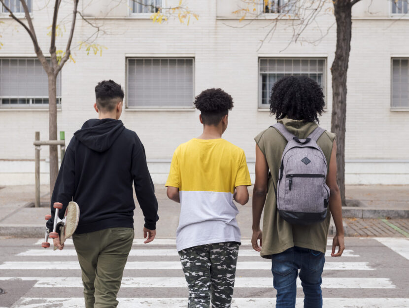 tre ragazzi minorenni camminano di spalle