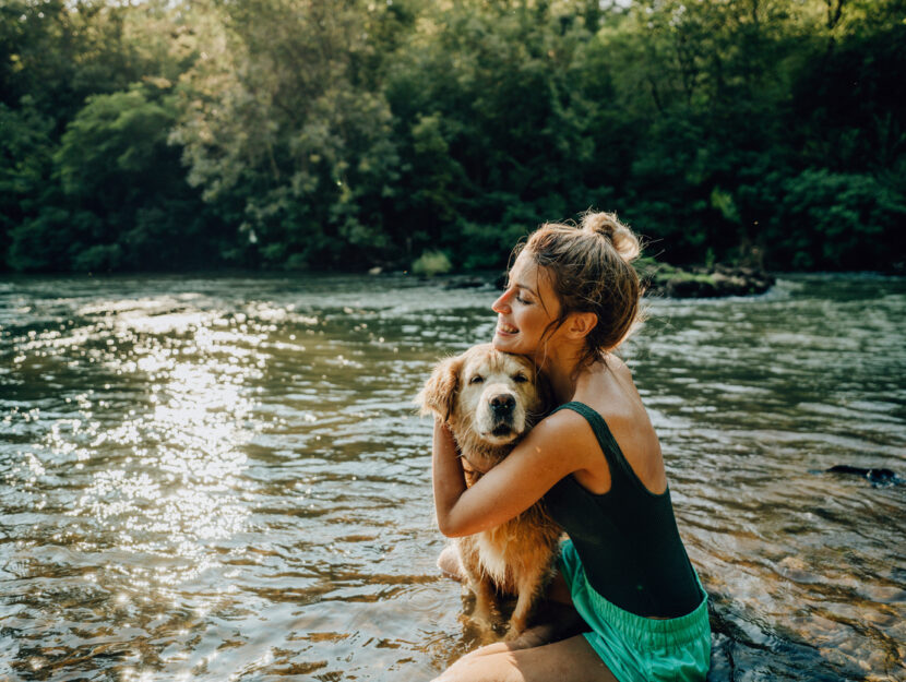 ragazza si fa il bagno al fiume con il cane