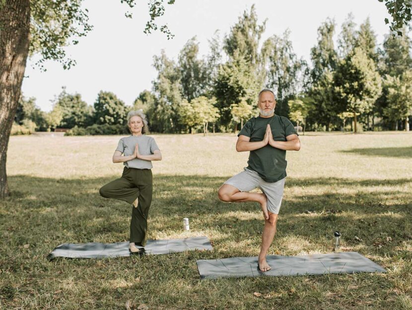 Coppia fa yoga al parco
