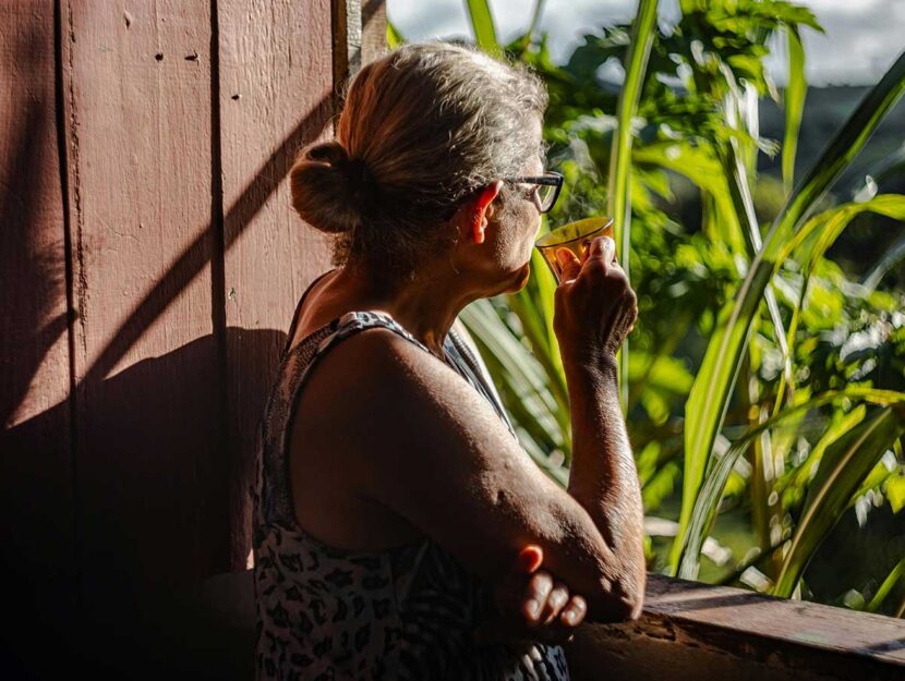 Donna beve il tè sul balcone di casa