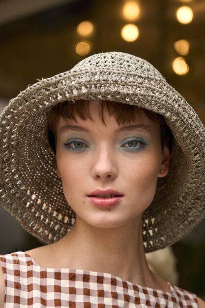 Ragazza con trucco estivo e cappello