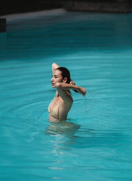 Ragazza in piscina sa come proteggere pelle e capelli
