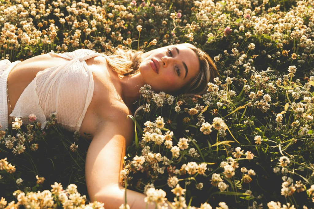 ragazza distesa su un campo fiorito