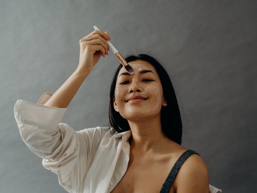 ragazza si sta applicando una maschera sul viso