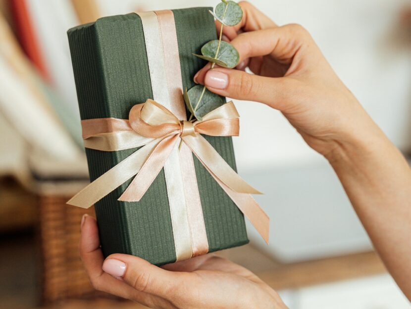 donna che confeziona pacco regalo