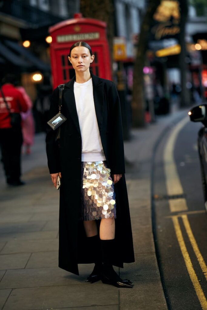 Ragazza con ginna paillettes e cappotto