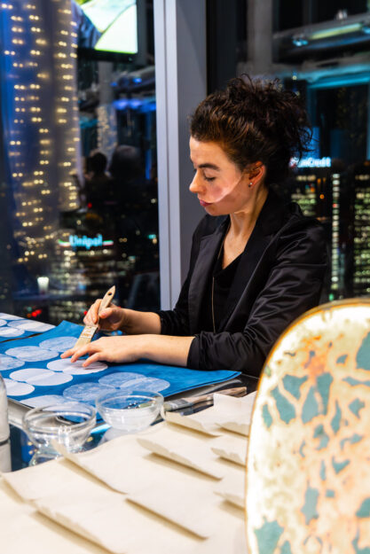 Una decoratrice di Fabscarte, atelier milanese specializzato in carte da parati artistiche e tridimensionali, realizza pitture dal vivo all'Evento Lombardia style Premium Brands