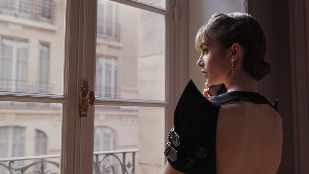 emily a Parigi guarda fuori da una finestra