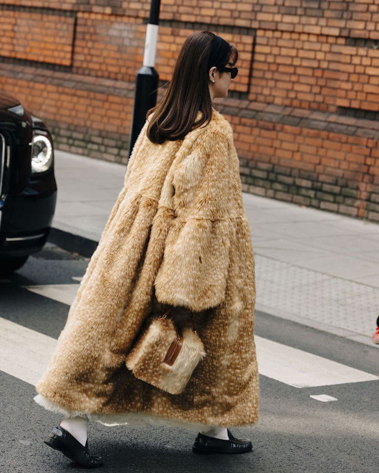Ragazza con cappotto e borsa stampa cervo