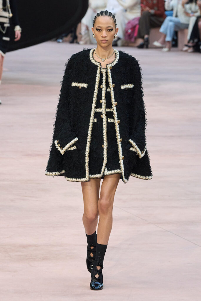 Una modella indossa una mantella alla sgilata Chanel